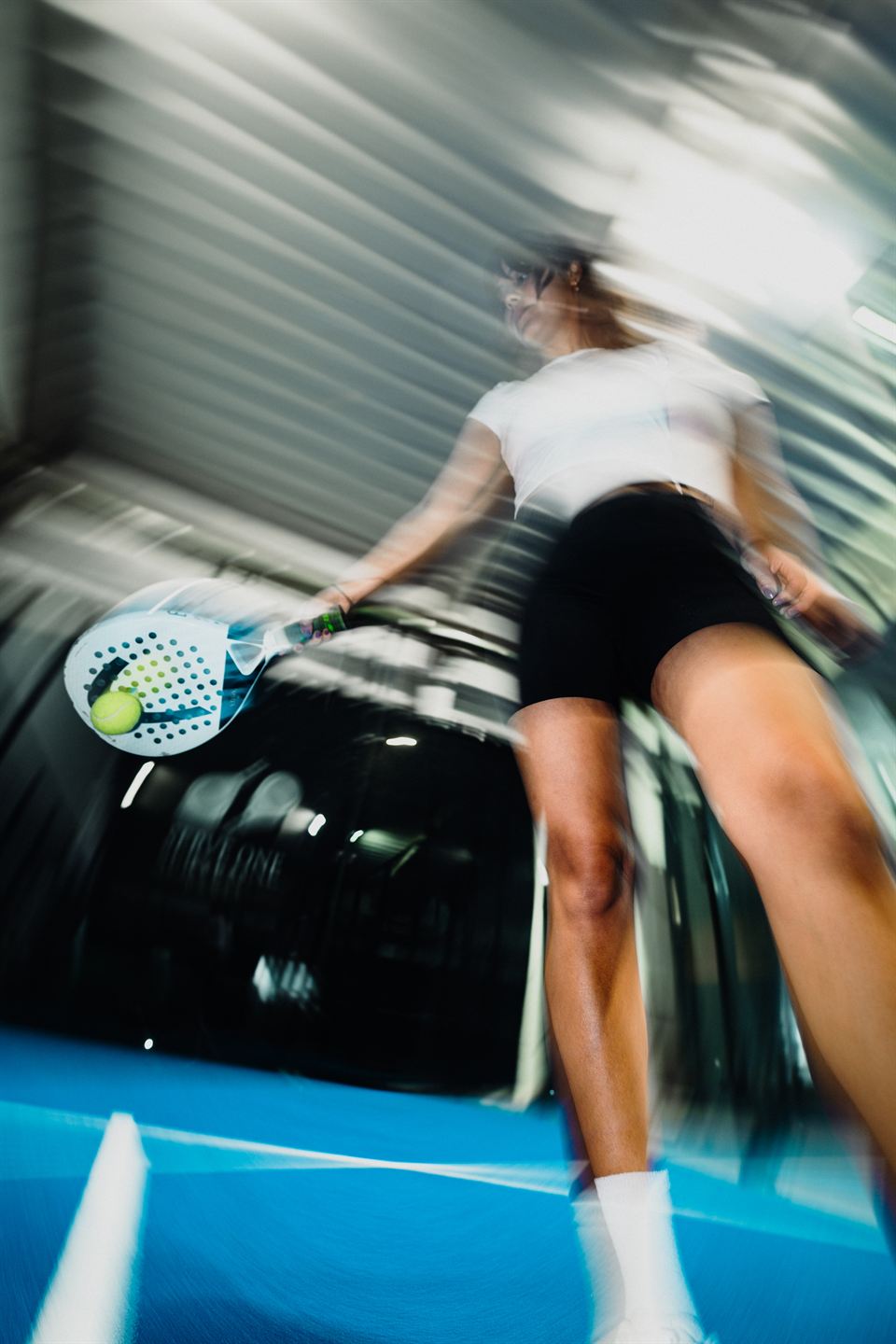 Spielerin schlägt den Ball auf dem blauen Court