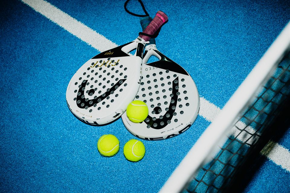 Zwei Schläger und Bälle auf dem blauen Court